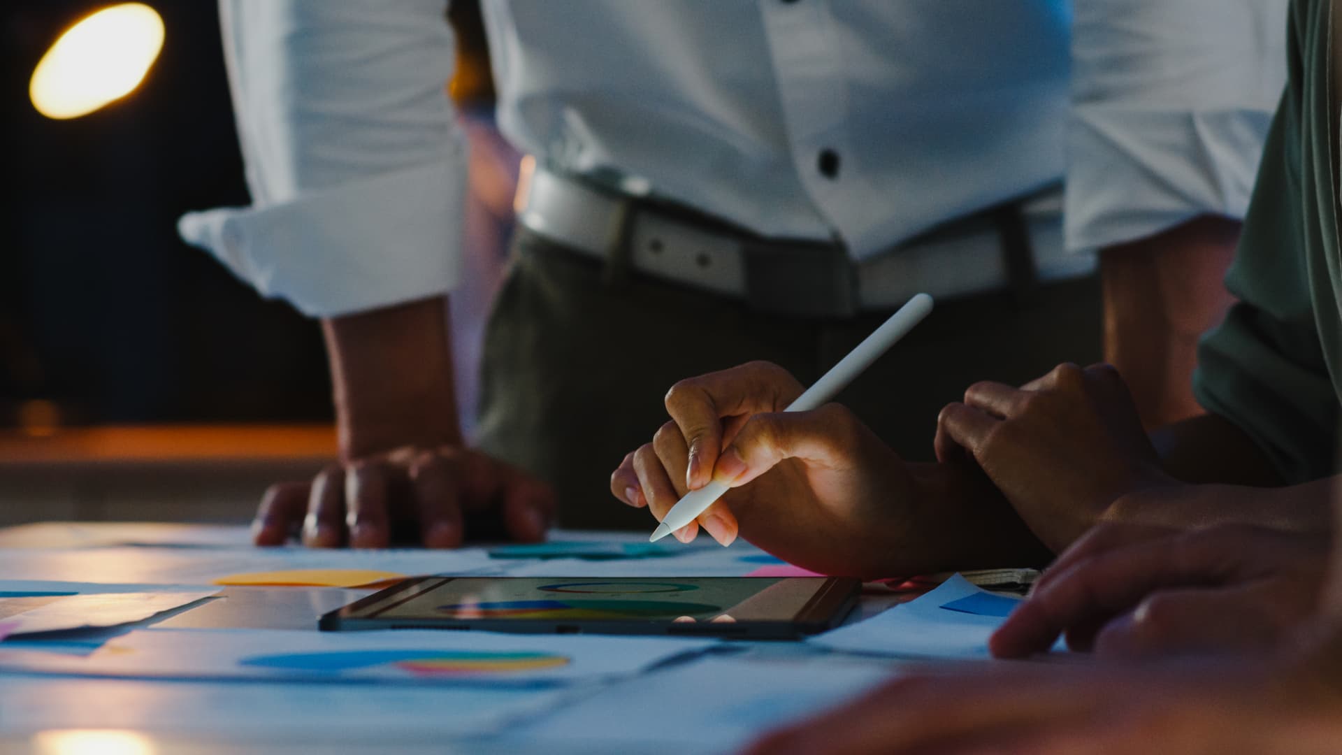 Business team reviewing performance charts on a tablet during a strategy session